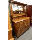 A late 19thC / early 20thC oak sideboard, the raised mirrored back with turned supports, the base