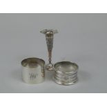 Two early 20thC silver napkin rings, and an Indian or Burmese white metal small bud vase. (3)