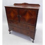 An Art Deco walnut cupboard, the top with a raised back above two doors and two drawers, each with