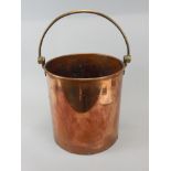 A 20thC riveted copper and brass coal bucket, with swivel handle, of cylindrical form, 29cm high