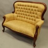 A modern mahogany finished two seater settee and button back gilt coloured material. The