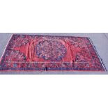 A Hamedan rug, on a red ground, 235cm x 130cm