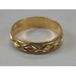 A wedding band, of part textured geometric outline, yellow metal, marked 375