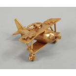 A 9ct gold bi-plane charm or pendant, the plane with propeller and wings designed with stars, 7g all