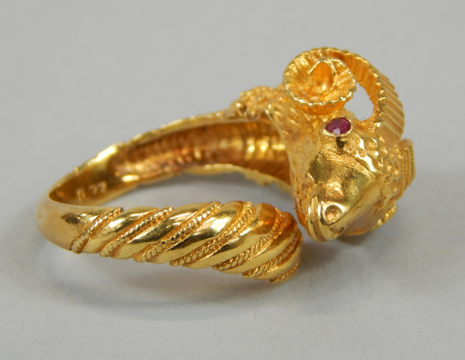 A ram's head ring, the head set with two rubies, yellow metal, marked 750, 9.1g all in.