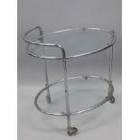An Art Deco style chrome plated oval two tier trolley, with two glass shelves.