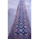 A Persian type runner, with a design of flowers within multiple borders, and bearing signature to