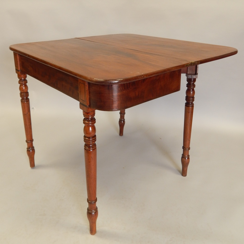 An early 19thC mahogany tea table, the rectangular top with rounded corners on turned tapering legs,