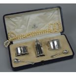 An Art Deco period George V silver three piece cruet, comprising pepper pot, mustard pot and open