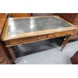 A Victorian oak writing table, the rectangular top with a green leather insert, above two frieze