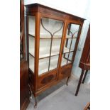 An early 20thC mahogany display cabinet, with two glazed doors, on cabriole legs, 103cm wide