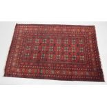 A Turkoman style rug, of geometric floral pattern, predominately in red, cream and blue, with a