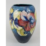 A Moorcroft bullet shaped vase, decorated with a band of Hibiscus flowers, on a navy ground,