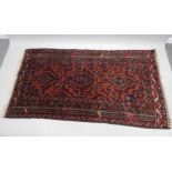 A Persian style rug, predominately in blue, red and brown, with a floral geometric pattern and