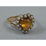 A ladies 9ct gold dress ring, the heart shaped centre with an amber coloured stone, claw set,