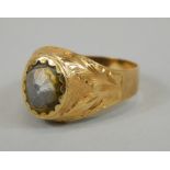 An 18ct gold gent's signet ring, the central brushed stone crudely set, 6.3g all in.