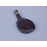 A 19thC British leather and brass shot flask, 17cm long.