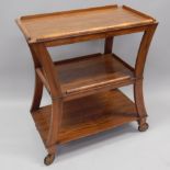 An Art Deco style walnut three tier trolley, with a raised gallery, on shaped supports, with