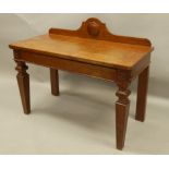 A late Victorian oak serving or hall table, with a raised back, the rectangular top with frieze