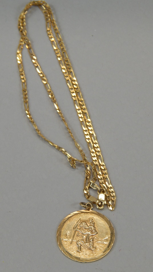 A 9ct gold St Christopher pendant, of circular outline with ring top, attached to a fancy link