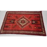 A Persian style rug, in geometric floral pattern, predominately in red, cream and black, 190cm x