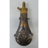 A brass powder flask, embossed with a leaves and shells, unmarked.