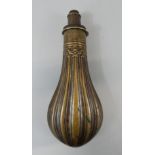 A brass powder flask, with ribbed decoration, stamped Dram.