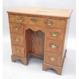 A walnut kneehole desk in mid 18thC style, the rectangular feather banded veneered top, with a