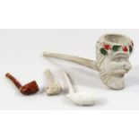 An early 20thC clay pipe, formed with a satyr head, with plain stem stamped Happy, 20cm wide,