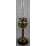 An early Edwardian brass oil lamp, with clear Cera chimney, the fixed reservoir on fluted base