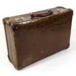 A 20thC faux crocodile skin leather suitcase, with chrome mounts, plain interior and swing handle,