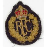 A Royal Flying Corps cloth badge, headed by a crown with gilt garland and raised initials, 11cm