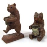 A heavily carved Black Forest bear thimble stand, the animal in seated position and another