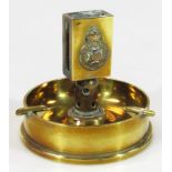 An early 20thC Trenchart brass vesta case, with Royal Malta Artillery centre, on a shell cased base,