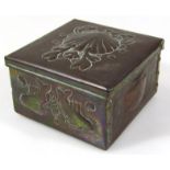 A late 19thC / early 20thC Newlyn copper box, the square body, with hinged lid, raised with a shell,