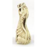 A 19thC ivory figure of a seated dragon, with head upright, part pierced mouth with decorative