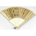 A 19thC ivory hand fan, with heavily carved ends and plain handle, with rice paper spokes,