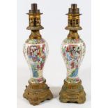 A pair of 19thC Chinese famille rose lamp vases, each inverted baluster body decorated with panels