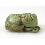 A polished green jade figure of a lion, recumbent position with smiling face, 6cm wide, unmarked