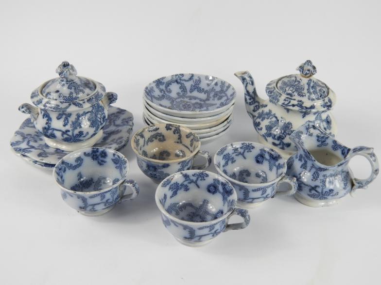 An early 19thC pottery child's part tea service, printed in flow blue with a floral sheet pattern,