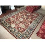 A red ground Persian design rug, with blue and ecru borders.