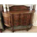 A serpentine carved oak sideboard.