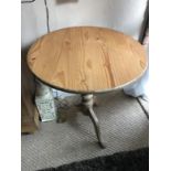 A stripped pine tripod supper table.