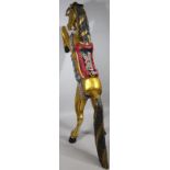 A large highly decorative wooden model of a rearing horse, wearing decorative tack on a gold