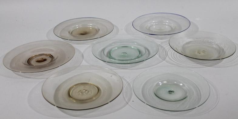 Seven various early 19thC glass saucers, each of dished outline with rough pontil marks, various