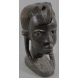 A 20thC heavily carved ebony African tribal figural head, with elaborate hair, facing forwards,