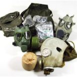 Various respiratory and gas masks, green rubber example in canvas bag stamped Gradana, 26cm wide. (a