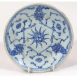 A Chinese porcelain blue and white saucer, of circular outline centred with a floral emblem