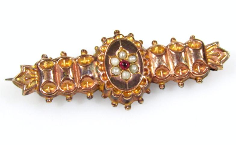 An early 20thC 9ct gold brooch, of fancy outline, with a floral centre set with seed pearls and a
