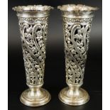 A pair of Edwardian silver specimen vases, with pierced floral design, with blue glass liners, and